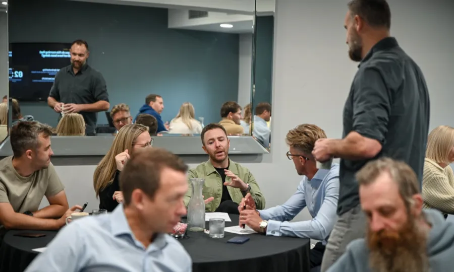 Delegates in discussion around a table while Chris listens