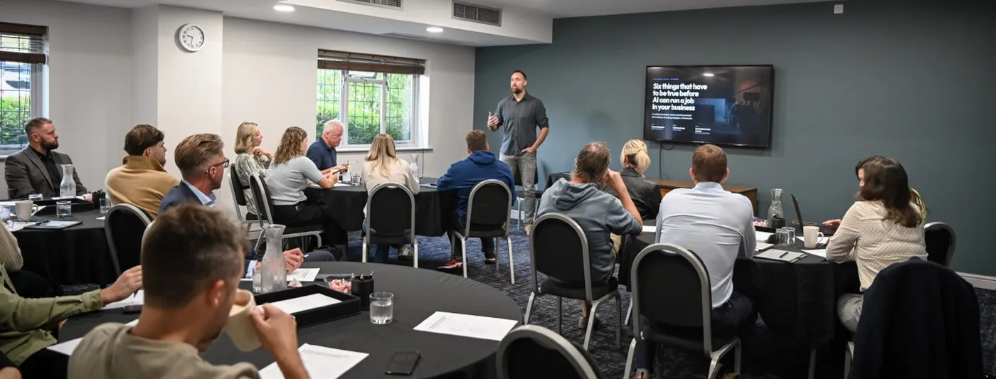 A full room of business owners at round tables listening to Chris Bedford present